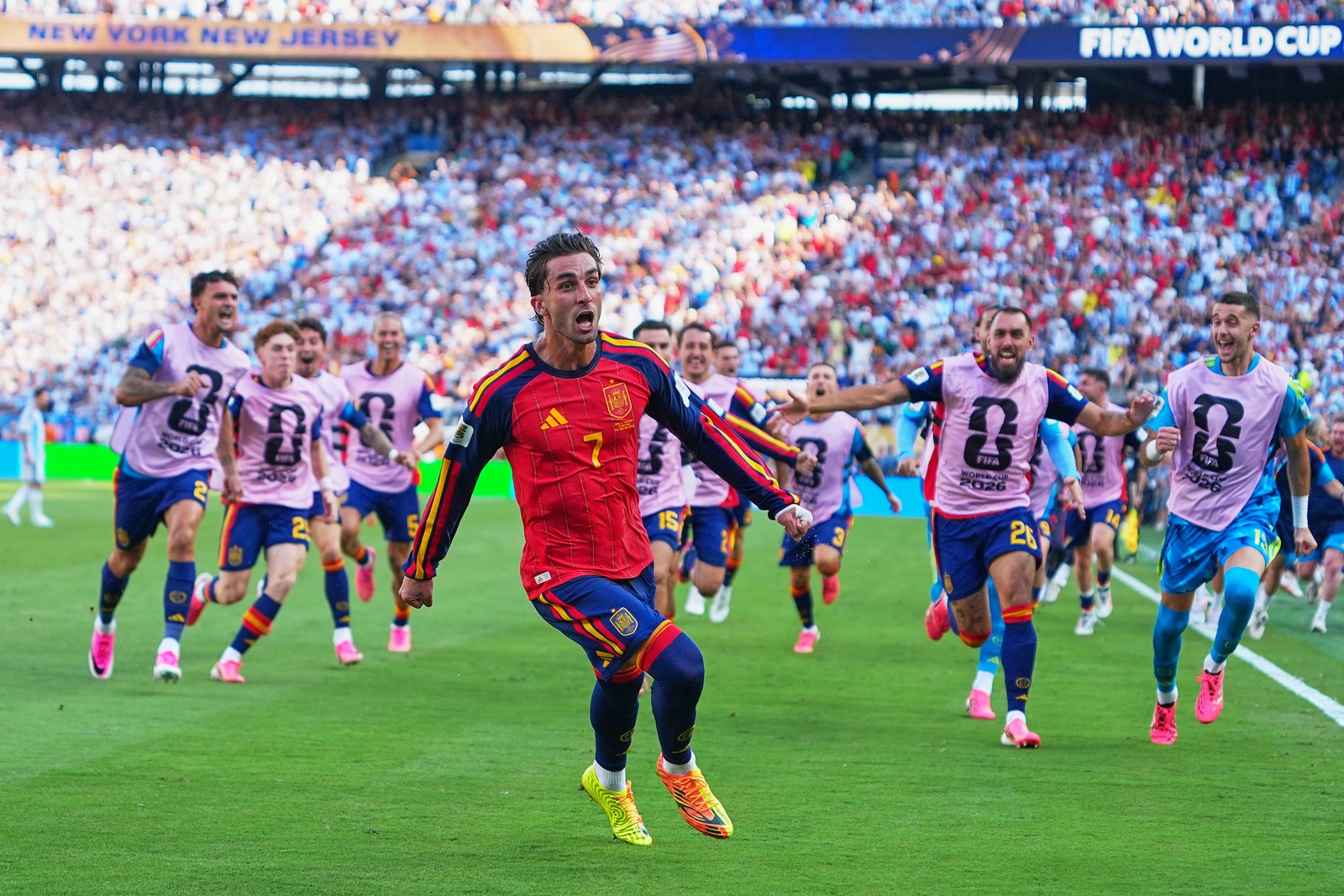 Ferran Torres celebrates the decisive goal as Spain's substitutes race onto the pitch.