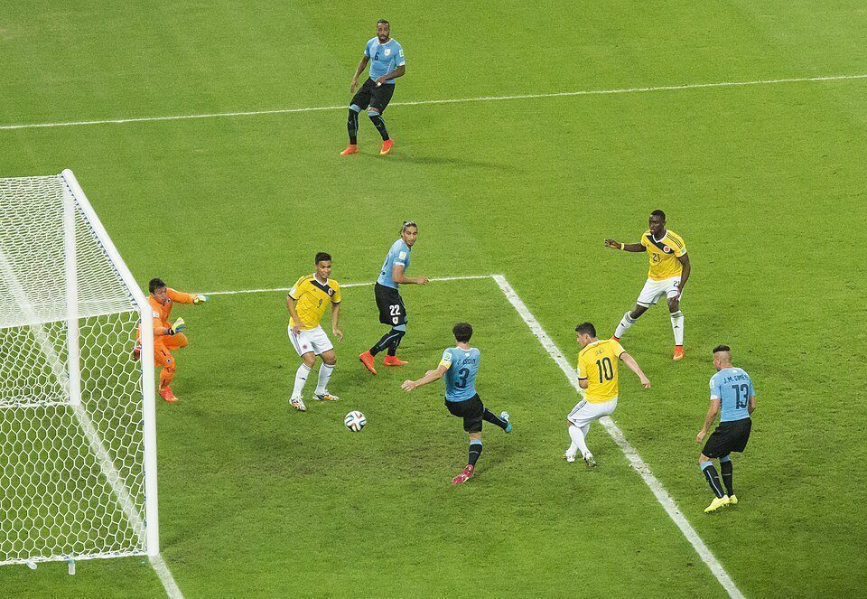 Ảnh tư liệu: James Rodriguez (áo vàng số 10) tranh bóng trong vòng cấm cùng màu áo tuyển Colombia, vây quanh là các cầu thủ Uruguay. Nguồn: Wikimedia Commons.